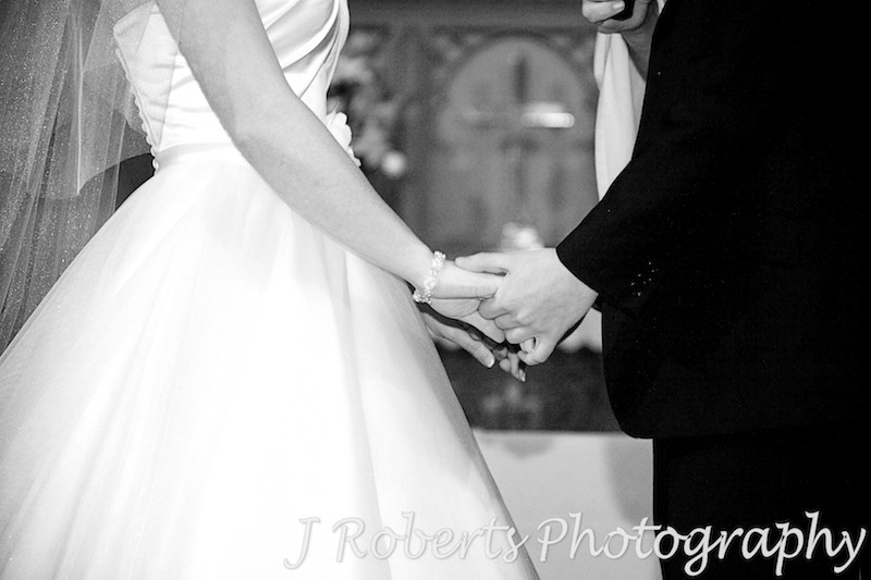 Bride and groom holding hands during wedding ceremony - wedding photography sydney